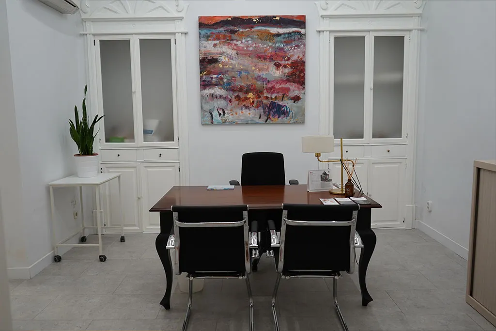 Sala de consulta con escritorio y vitrinas blancas